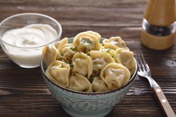Plate of traditional Russian dumplings, ravioli on a dark wooden background.