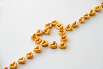 Whole grain oat cereal in a heart shape on a white background, back view. Heart shapes cereal. 