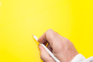 Colored pencil in the hand of an adult person