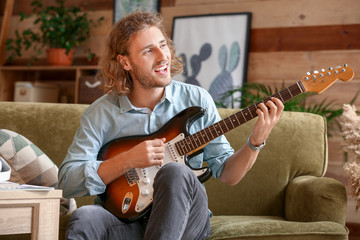 Man playing modern guitar at home