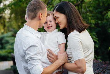 Fototapeta premium Happy family with their son walking in the Park at sunset. Happiness. Love