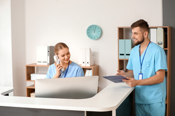 Male doctor near reception desk in clinic