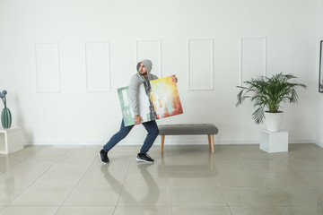 Thief stealing picture from art gallery