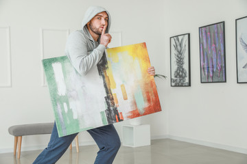 Thief stealing picture from art gallery