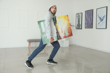 Thief stealing picture from art gallery