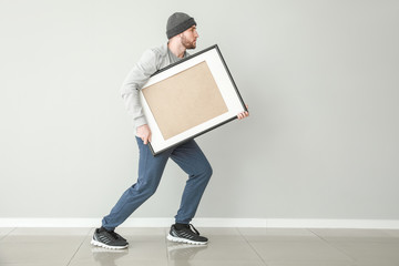 Thief stealing picture from art gallery