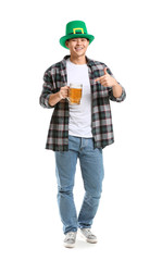 Young Asian man with beer on white background. St. Patrick's Day celebration
