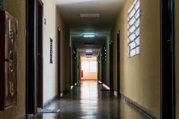 Dark corridor in modern building with a bright window at the end