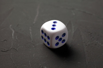 game dice lies on a dark background