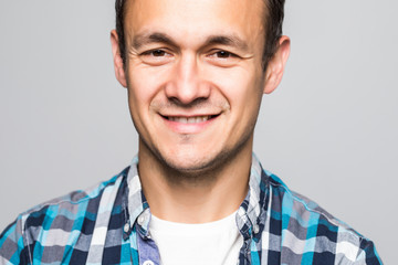 Obraz premium Young smiling optimistic man in t-shirt standing isolated on light gray background