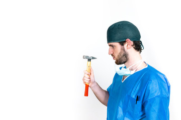 Chirurgo ortopedico con casacca operatoria blu e con martello e sfondo bianco
