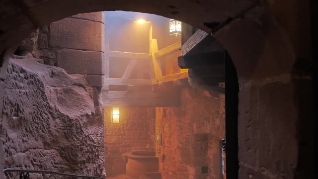 Pasadizo del terror en castillo con bruma y farolas naranjas terror&iacute;ficas