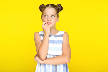 Young beautiful girl thinking on yellow background