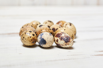 Fototapeta premium quail eggs on a light wooden background.