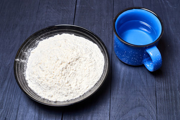Plate with flour on a dark background.