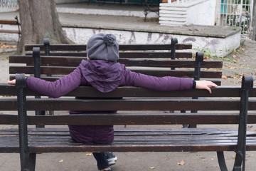girl sitting on an old park bench