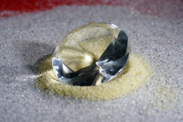 Artificial diamonds lying in the sand photographed in the studio with flash light