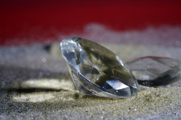 Artificial diamonds lying in the sand photographed in the studio with flash light
