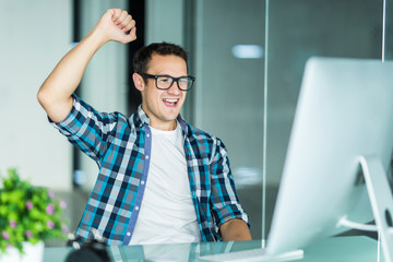 Euphoric happy businessman celebrate mobile win in office