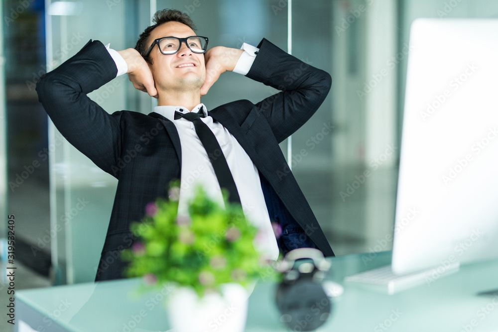 Wall mural Successful young businessman relaxing in his office