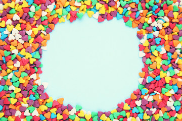 Colorful heart shaped sprinkles on blue background