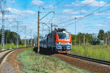 Modern high-speed train moves through the station at spring morning time.