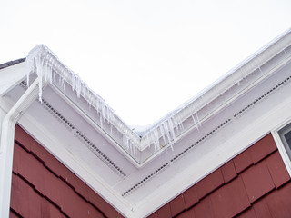 Obraz premium icicles hanging from the roof gutter in winter