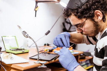 Technician changing tablet touch screen