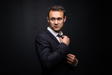 Obraz premium Young handsome businessman on a black background