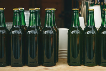 Green bottles with a drink in a row