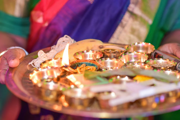 Colourful traditional view of bengali wedding rituals with multiple brass made bowls on brass plate holding fire in india