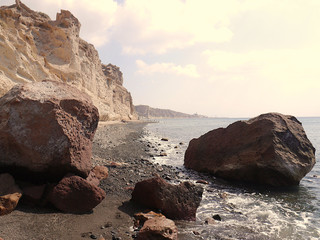 Landscape with cliffs and large stones on the coast near Akrotiri. Santorini, Greece.