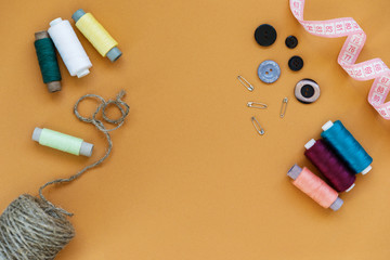 Group of sewing objects lying flat on a colorful background. Horizontal background for ad or packaging.