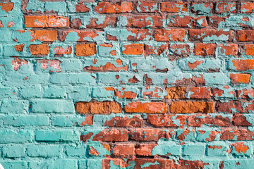 The wall of the old building. Cracked paint. Turquoise-red wall.