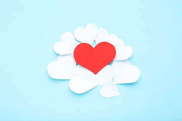 Red and white paper hearts on blue background