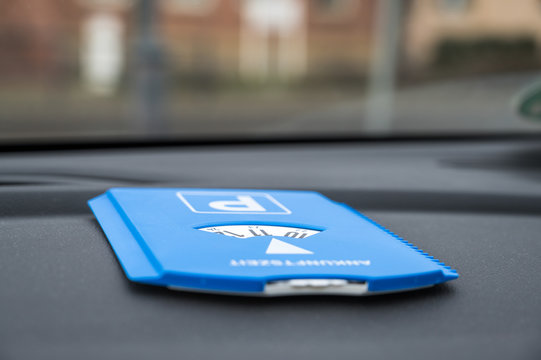Blaue Parkscheibe liegt auf dem Armaturenbrett eines Autos