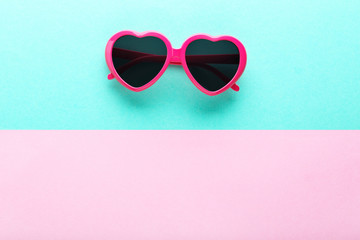 Modern heart shaped sunglasses on colorful background