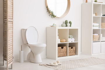 Modern toilet bowl near white wall in bathroom - obrazy, fototapety, plakaty