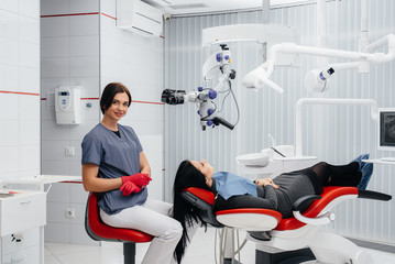 The dentist looks through a microscope and performs surgery on the patient