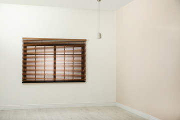 Window with brown blinds in empty room