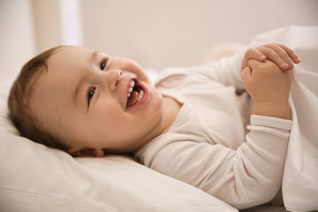 Cute little baby lying in comfortable crib. Bedtime