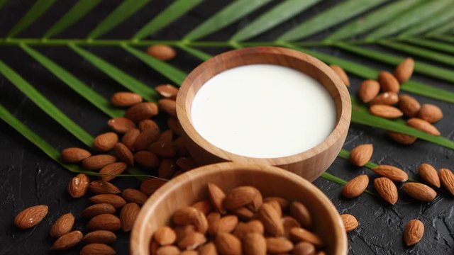Close up of Almonds in wooden bowl and almond milk