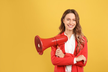 Young woman with megaphone on yellow background