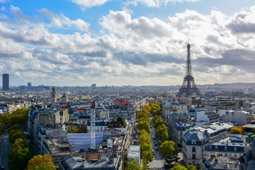 Fototapeta premium Colorful skyline of Paris, France, with the Eiffel Tower, the dome of Les Invalides, Montparnasse tower and famous Parisian boulevards on a sunny autumn day, captured from the top of Arch de Triomphe 