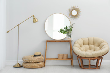 Stylish round mirror near white wall in room