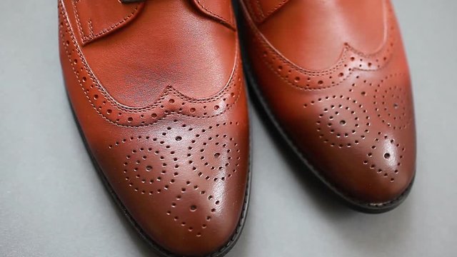Oxford male brogues shoes. Men's fashion. Classical brown leather footwear on grey background