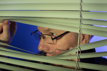 Man peeking through blinds