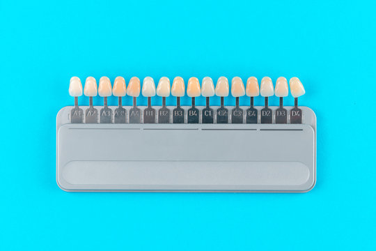 shade guide to accurately determine tooth shade, palette for choose color tone of teeth isolated on blue background, top view, flat lay - Powered by Adobe
