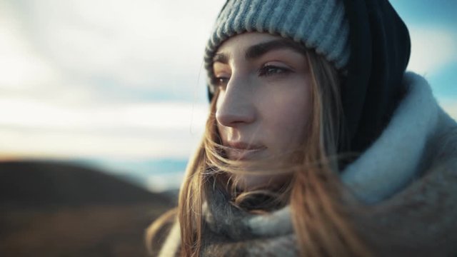 Side close up view of beautiful caucasian woman's face dreaming looking to the great view the wind flutters hair trip adventure landscape outdoor pure nature slow motion portrait mountain hill
