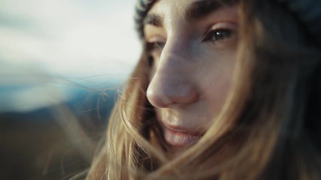 Extrime close up view of pretty woman opening eyes and looking wind blowing her hair sun shine outdoor trip adventure landscape pure nature slow motion portrait enjoy relax